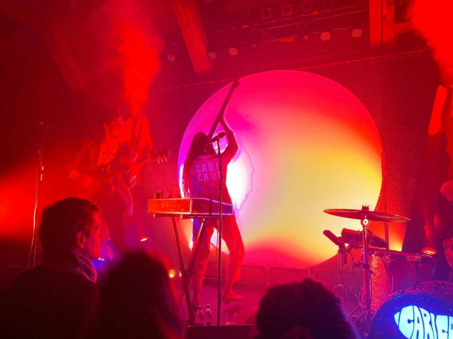 Muzycy grają energetyczny koncert na zadymionej scenie.